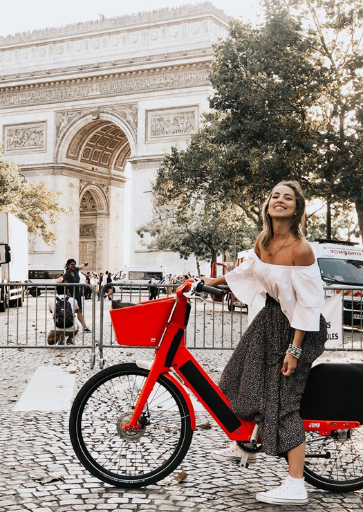 Mulher em bicicleta pelo Arco do Triunfo