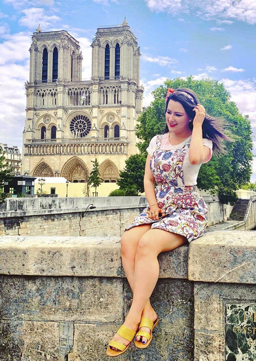 Menina sentada em frente Notre Dame