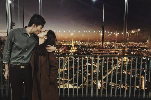 Casal dando um beijo na Torre à noite