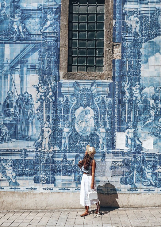 Menina olha azulejos de Capela das Almas