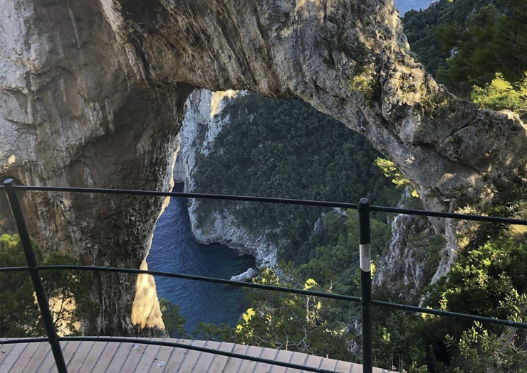 Vista do arco de rocha natural com o mar ao fundo. enquadramento vertical.  ilha de capri, itália.