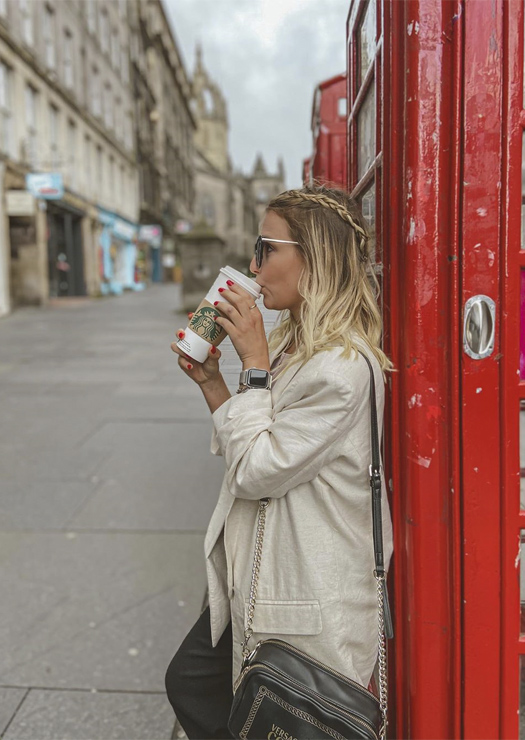 Menina tomando café na Royal Mile
